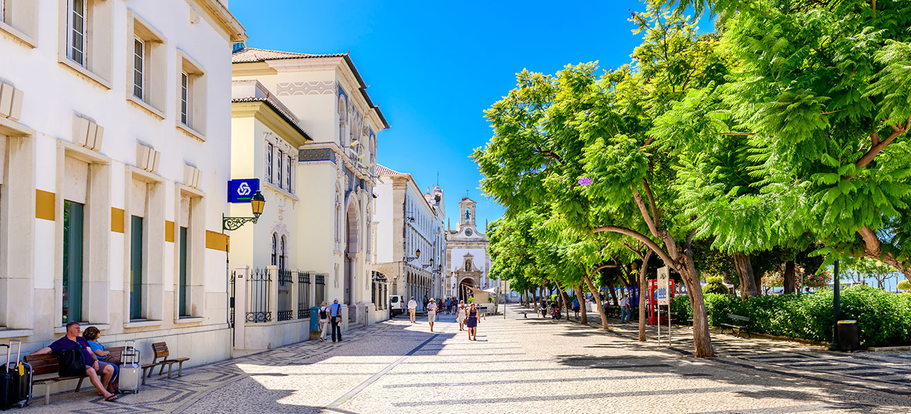 Street scene in Faro with Arco da Vila in the distance